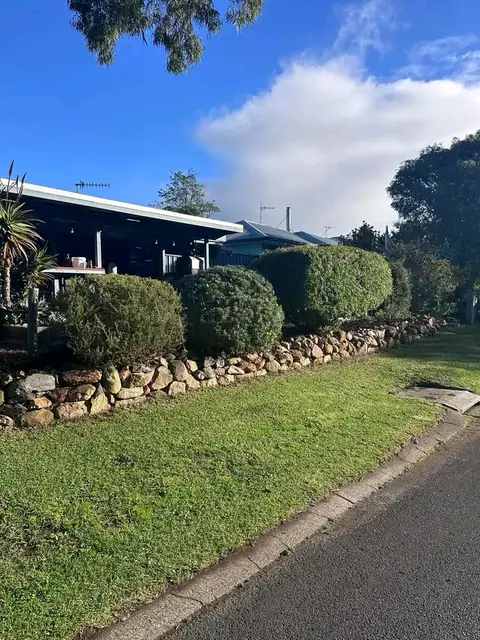 Trimmed hedges and rock wall along a Margaret River street